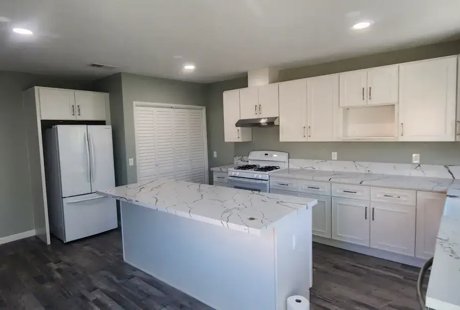 Modern kitchen with white cabinets and island.