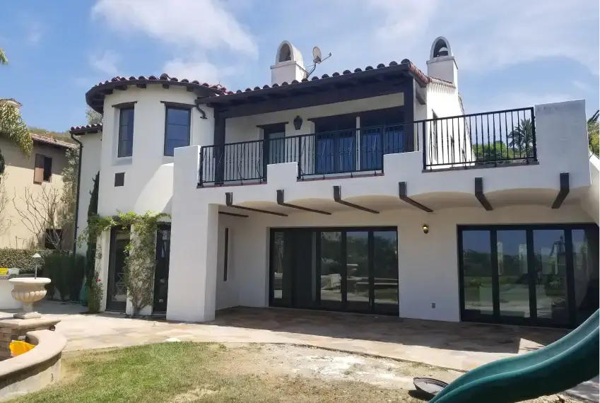 Two-story house with balcony and patio.