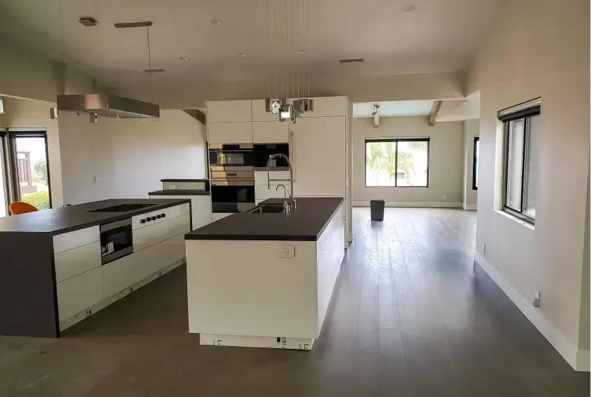 Modern kitchen with island and large windows.