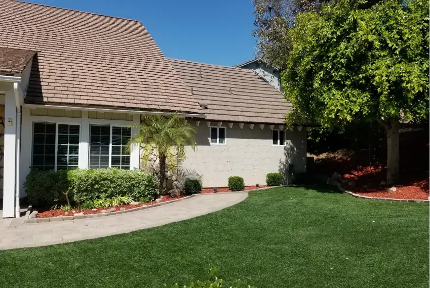 House with garden and green lawn.